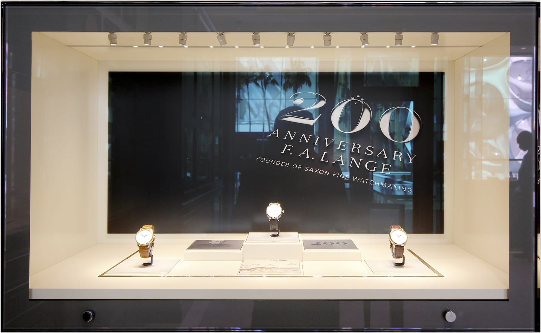 A. Lange und Söhne shop window with three-dimensional dark font as background and three clock models in front