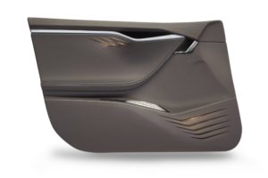 Car door interior trim of dynamic shapes with armrest, door handle and adjustment panel covered in brown leather with integrated indirect lighting through grooves