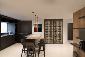 Apartment R1 visualization of modern dark kitchen with wooden wall paneling, bar stools and wine shelf