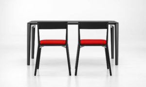 Finn Chairs with special attachment of the legs out of dark wood to the backrest and red upholstered seat, which generates an interesting gap with table in background
