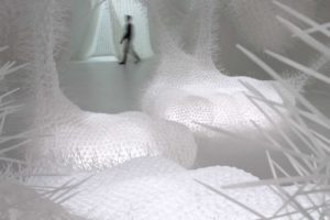 Third Space spatial installation made of white woven cable ties with wild spiky structure emerges pillows, columns and nets with lightning