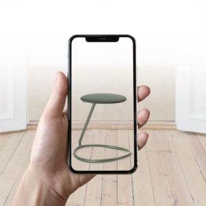 Rocca Hocker mit gebogenem Stahlrohr Ring zum Wippen als Standbein und Sitzpolster in dunklem grün virtuell auf Smartphone dargestellt