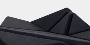 Cay Sofa mit verschiedenen geometrischen Polstern in verschiedene Richtungen gedreht und mit dunkel grauem Stoff überzogen