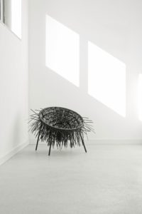 Oricio Lounger made of interwoven zip ties with wild spiky structure in light room