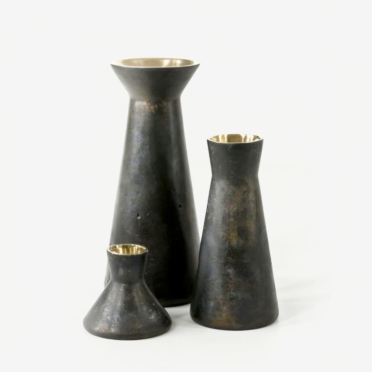 Three Y-01 Vases in three sizes in simple tapered shape with collar on top made of bronze. Inside surface is gold and shiny and outside dark and matt