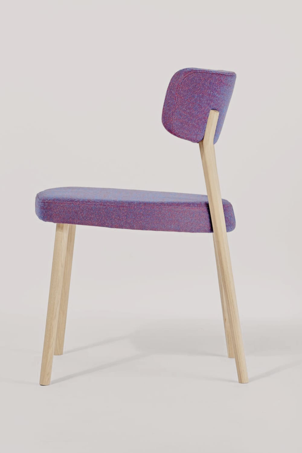 Marlon Dining Chair Stuhl mit breiter Rücken- und Sitzfläche in moderner dynamischer Form mit hellem Stoff überzogen und hellen Beinen aus Holz mit schlichtem Tisch